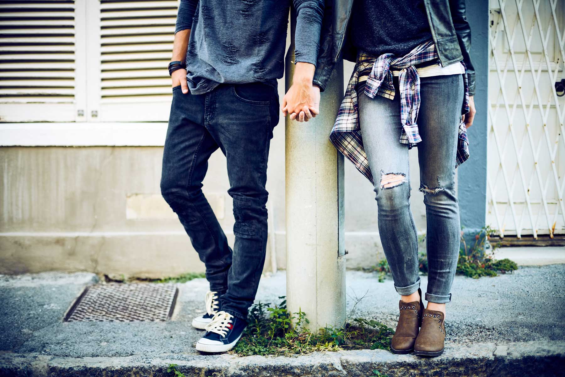 Low section of couple holding hands at pole